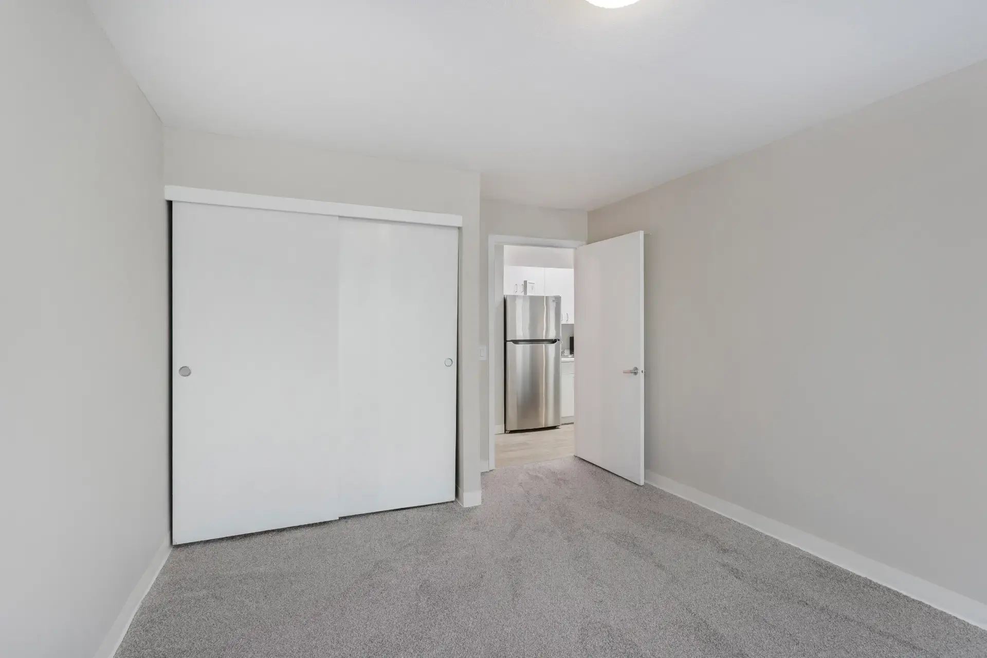 Room with closet and door to kitchen.